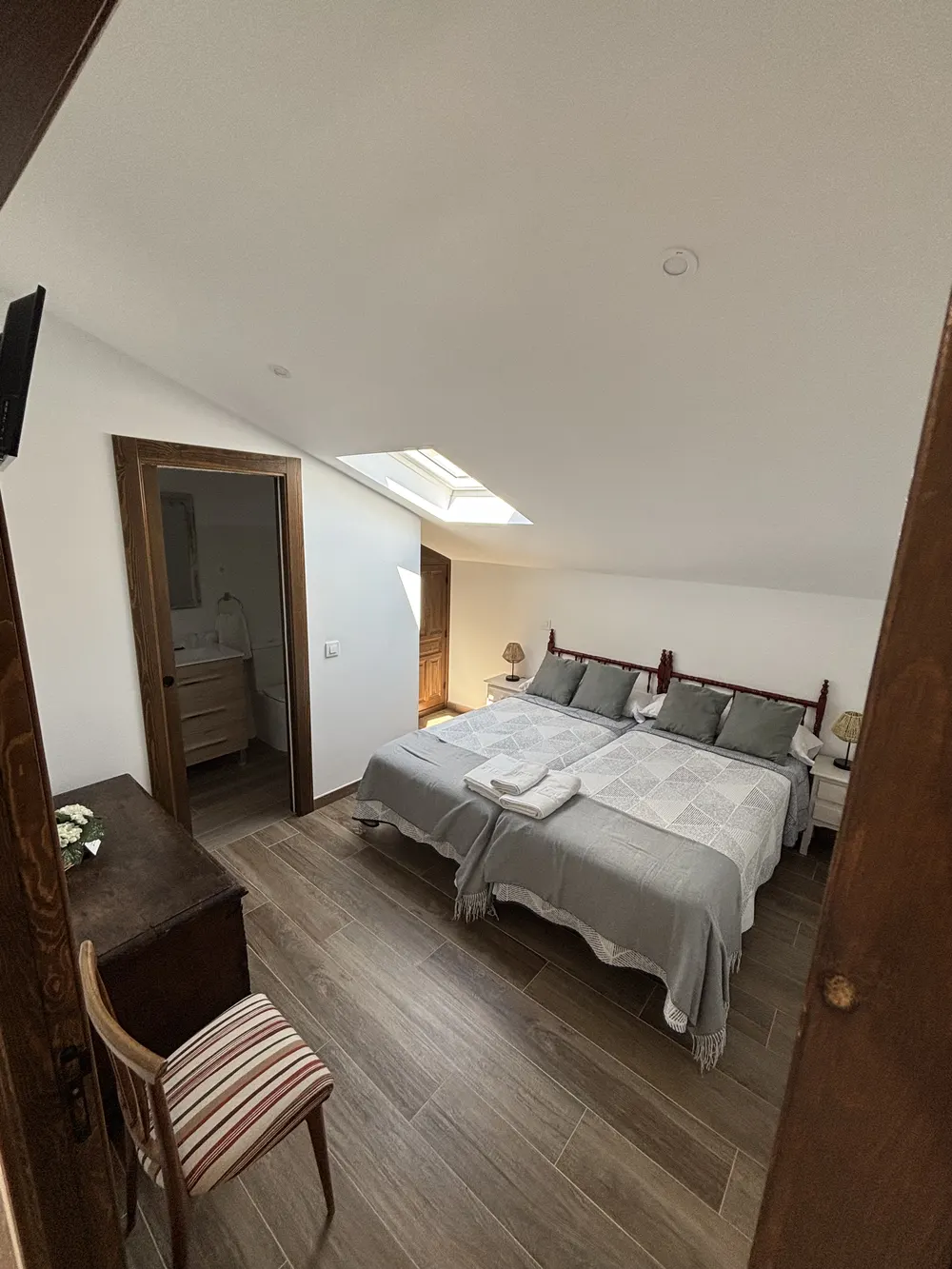 Dormitorio con dos camas y ropa de cama gris