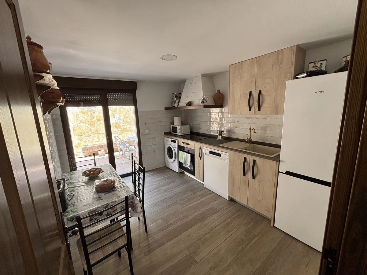 Cocina de la casa con office, lavadora y salida a la terraza