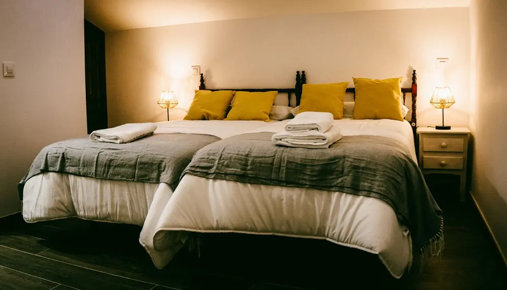 Dormitorio doble con dos camas y detalles en amarillo