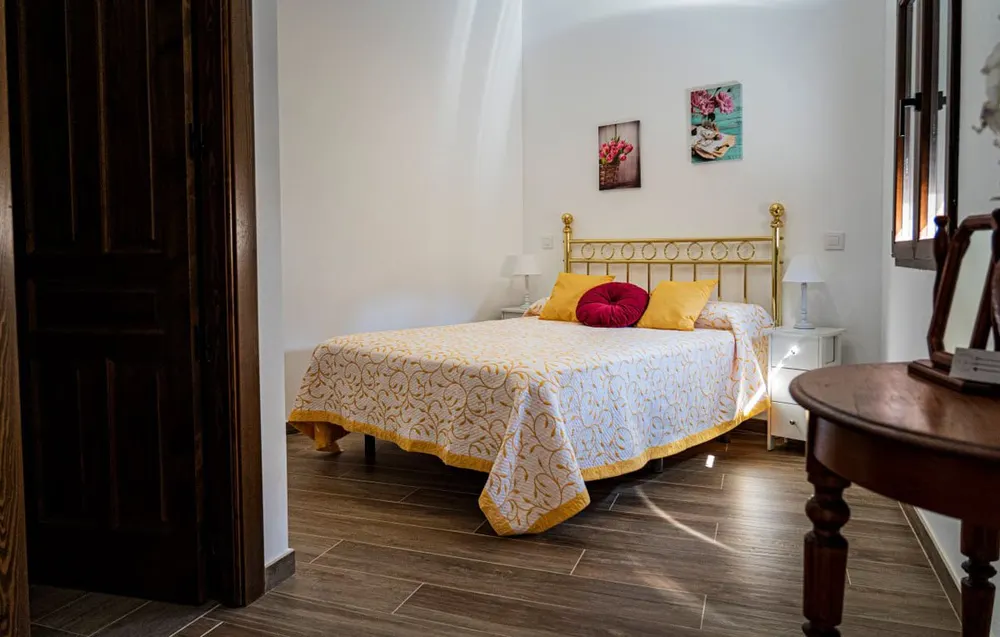 Dormitorio doble con ropa de cama blanca y toallas preparadas