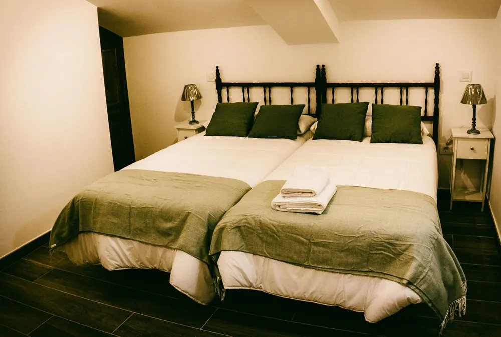 Dormitorio con dos camas individuales y ropa de cama en verde