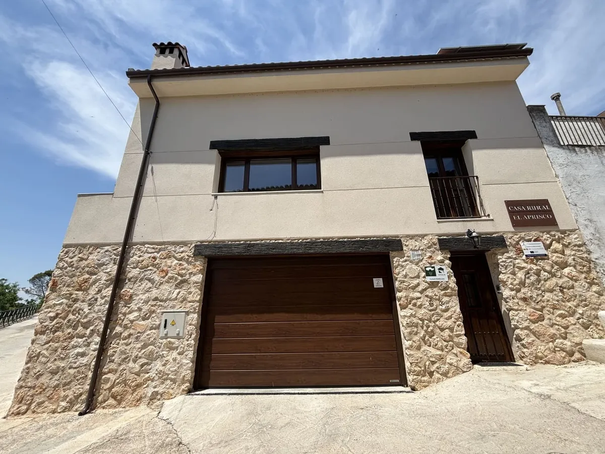 Fachada de piedra y garaje de Casa Rural El Aprisco en Hueva, Guadalajara