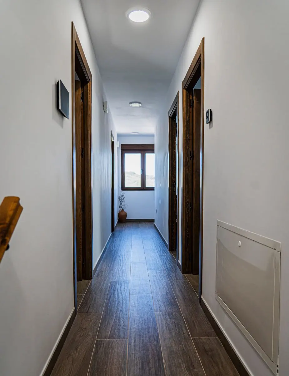 Pasillo interior de la casa con puertas de madera maciza