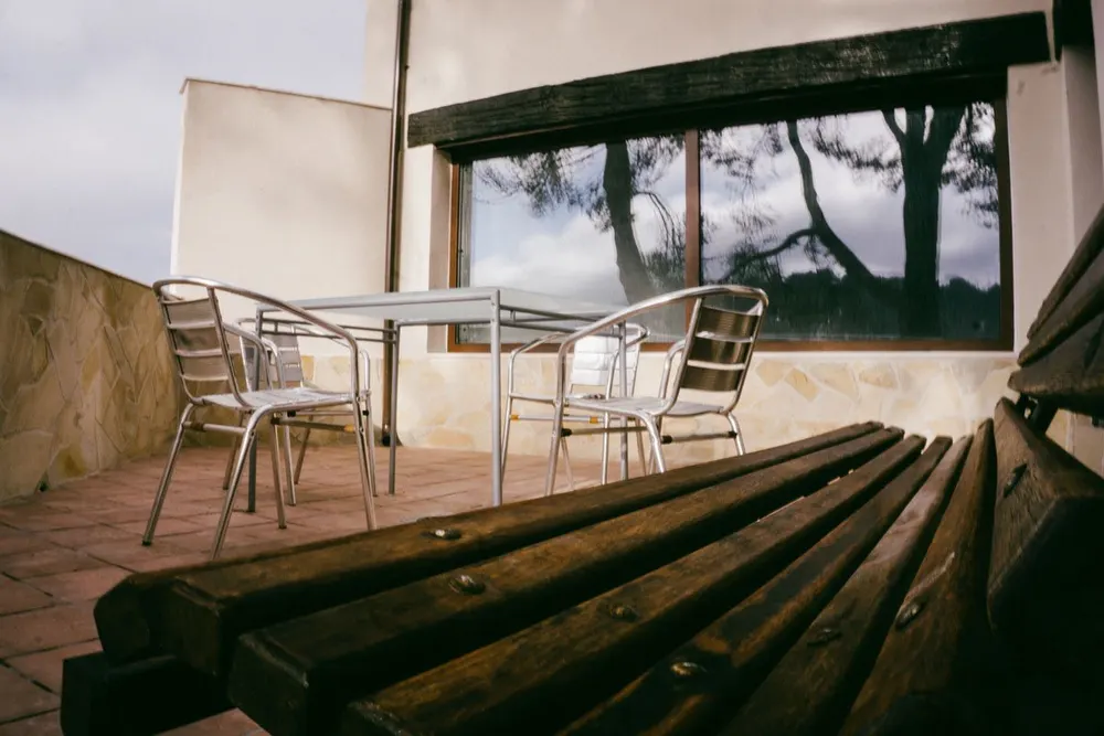 Terraza exterior con mesa y sillas y vistas a los árboles